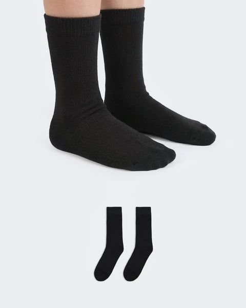 Black socks worn by a person on a white background